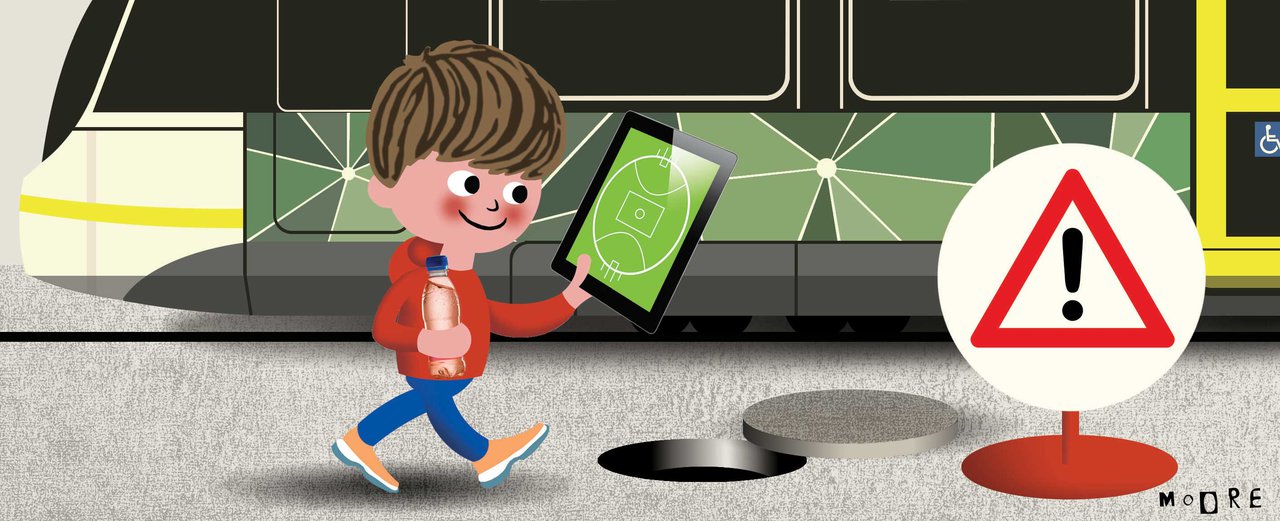 Illustration of a young boy walking along a footpath, holding a softdrink and staring at a tablet device with an AFL football field on it – so he can't see the warning sign and open manhole in the footpath in front of him, which he is about to fall into.