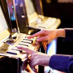 Two hands on the buttons of a pokie machine