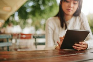 A young woman using tablet outdoors